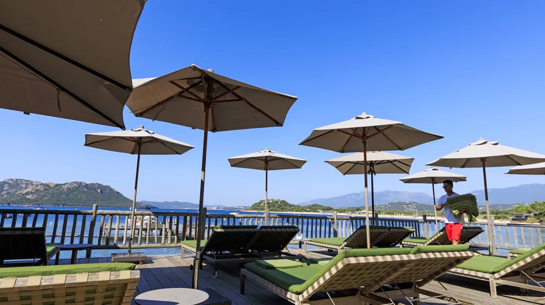 Terrasse de l'hôtel avec ses parasols et ses transats, en bord de la baie de Porto-Vecchio
